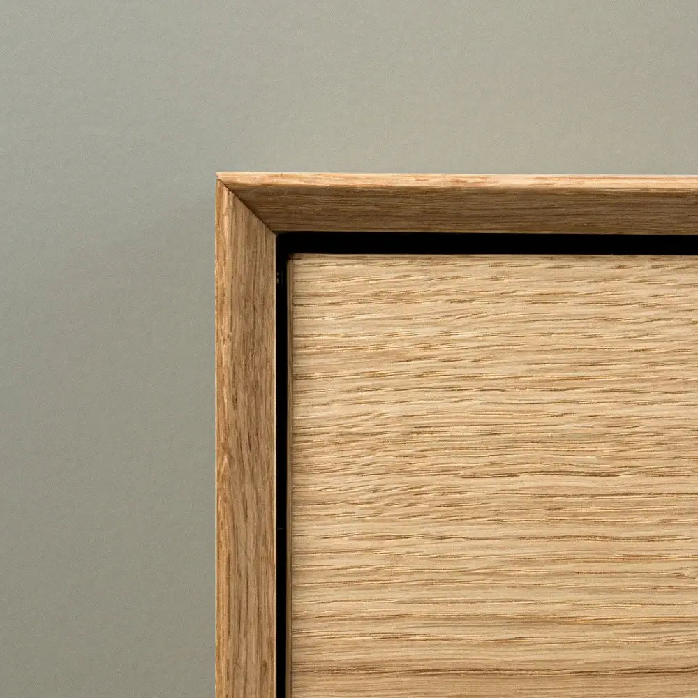 detaljeret billede af skoskab i egetræ med minimalistisk design og skrå ramme, produceret i Europa.