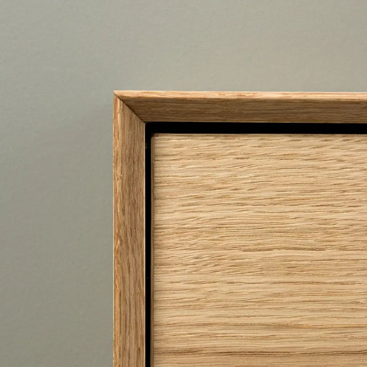 detaljeret billede af skoskab i egetræ med minimalistisk design og skrå ramme, produceret i Europa.